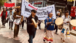 Boston Indigenous Peoples Day march with banner and drums
